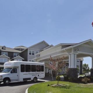 A view of a large building with a shuttle bus parked near the entrance.
