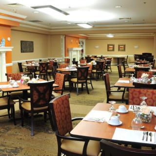 A well-appointed dining room with neatly arranged tables and chairs, featuring elegant place settings.