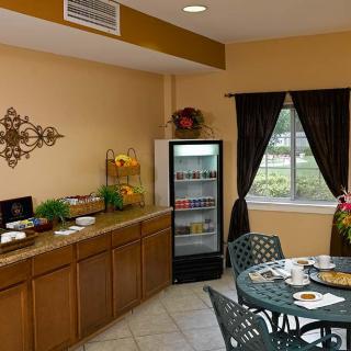 A cozy dining area with a table and chairs beside a kitchenette featuring a refrigerator and countertop.