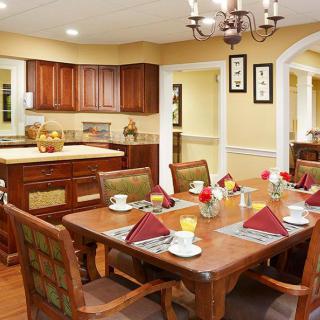 A cozy dining area with a set table adjacent to a kitchen.