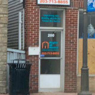 A storefront entrance with signage indicating services offered, set in a brick building.