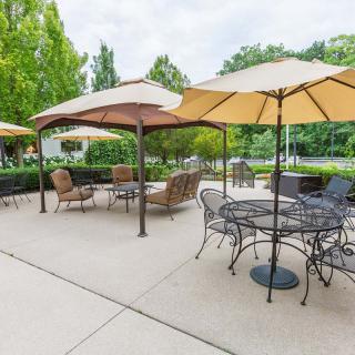 A peaceful outdoor patio area with tables, chairs, and umbrellas set up for relaxation.