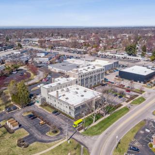 Aerial view of an urban area featuring buildings, roads, and parking lots.