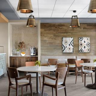 A modern cafe interior with wooden furniture and decorative wall art.