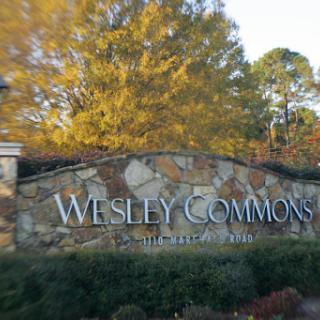 Wesley Commons entrance sign surrounded by vibrant autumn foliage.