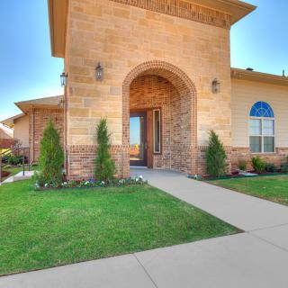 A modern house with a brick exterior and a well-maintained entrance pathway.