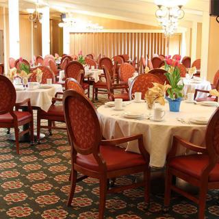 An elegant restaurant dining room set with tables and chairs.