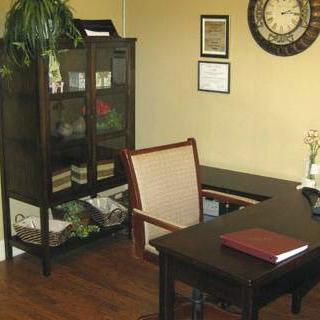A neatly organized office space featuring a desk, bookshelf, and decorative elements.