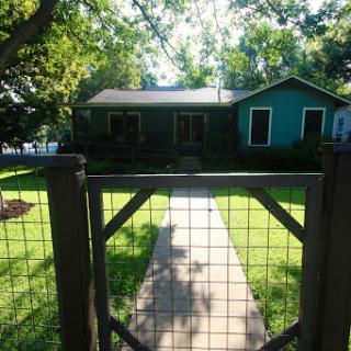 A charming house surrounded by greenery and a welcoming pathway.