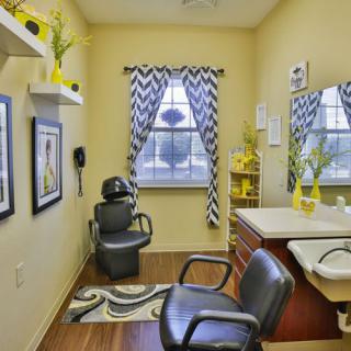 A modern hair salon with stylish chevron curtains and yellow accents.