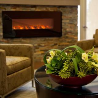 A cozy living room with a modern fireplace and elegant floral arrangement.