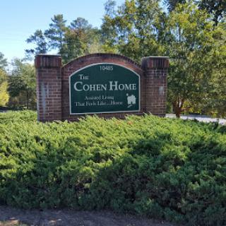 Entrance sign for The Cohen Home, surrounded by lush greenery.