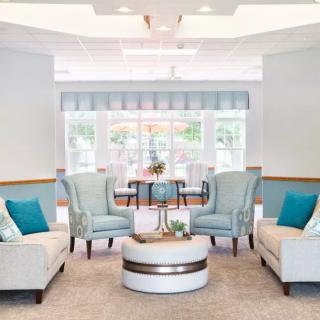 A modern living room with comfortable seating and turquoise accents, bathed in natural light.