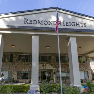 Front view of the Redmond Heights building with prominent columns and a flagpole.