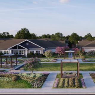 A scenic view of landscaped gardens and pathways in front of a residential building.