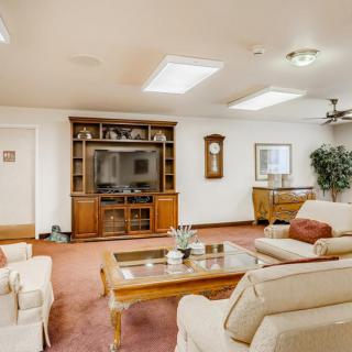 A cozy living room with a television, wooden furniture, and elegant decor.