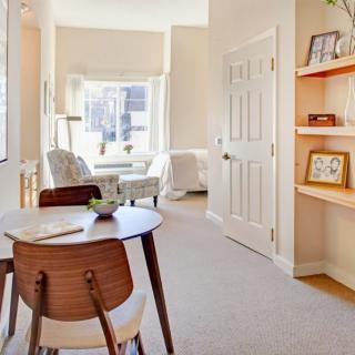 A bright and modern living space with a dining area, featuring natural light and stylish furniture.