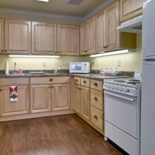 A modern kitchen with wooden cabinets and appliances.