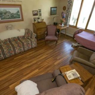 A cozy living room with wooden floors and a variety of furniture including sofas and chairs.