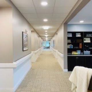 A long office hallway with light fixtures and carpet.