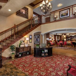 A luxurious hotel lobby featuring a grand staircase and elegant decor.