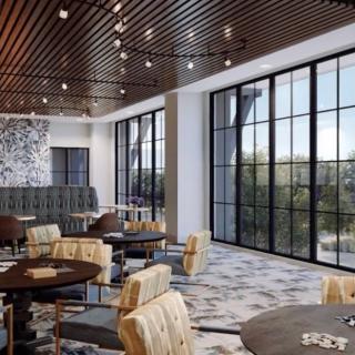 A modern restaurant interior with stylish furniture and large windows.