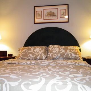 A cozy bedroom setup with a patterned bedspread and warm lighting.