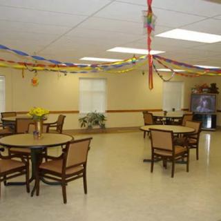 A decorated dining room with tables and chairs, featuring colorful streamers and a vending machine.