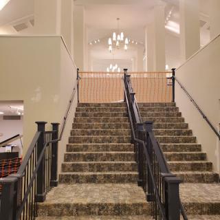 A view of elegantly designed stairs leading to a well-lit upper level.