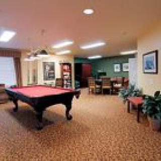 A cozy game room featuring a pool table and comfortable seating areas.