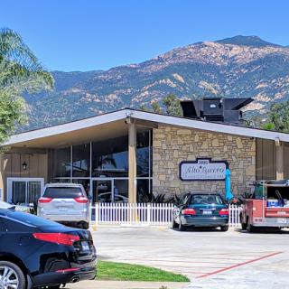 A modern commercial building set against a scenic mountain backdrop.