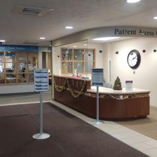 The reception area of a hospital, featuring an information desk and signage.