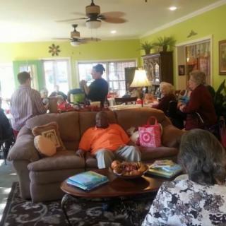 A group of people gathered in a cozy living room for a social event.