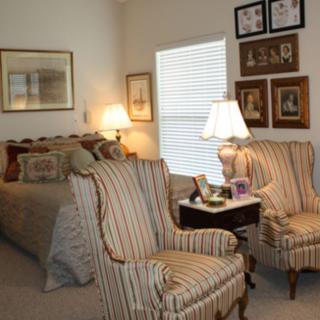 A cozy bedroom with striped chairs and decorative elements.