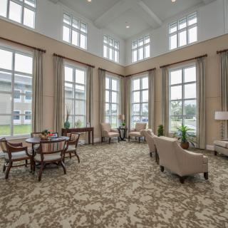 A spacious lobby with large windows, featuring comfortable seating and ample natural light.