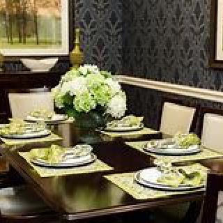 An elegantly set dining table with floral centerpiece and coordinated decor.