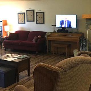 A cozy living room with a sofa, television, and wooden furniture.