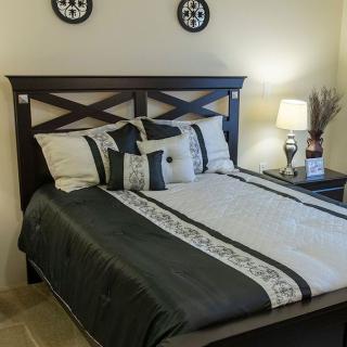 A neatly arranged bedroom with a stylish bed and matching decor.
