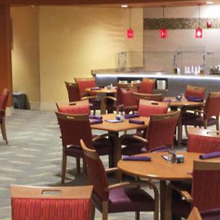 An empty restaurant dining area with neatly arranged tables and chairs.