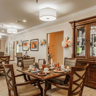 A cozy dining room with elegantly set tables and warm decor.