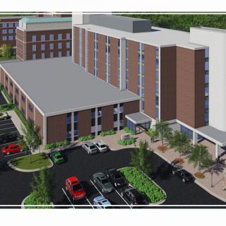 A modern hospital building with a parking area in front.