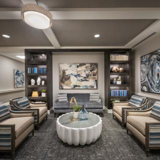 A stylish and modern living room with comfortable seating, artistic decor, and well-organized shelves.