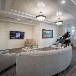 A modern living room featuring elegant decor, a grand piano, and contemporary lighting.