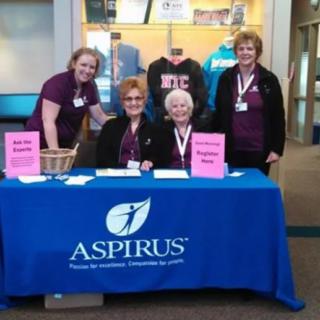 Volunteers at a registration table for an event, featuring Aspirus branding.