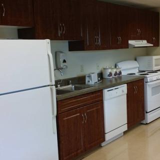 A modern kitchen equipped with essential appliances and wooden cabinets.