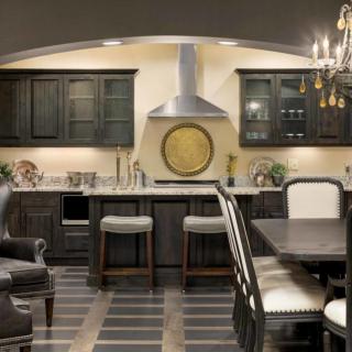 A modern kitchen and dining area with dark cabinets and stainless steel appliances.