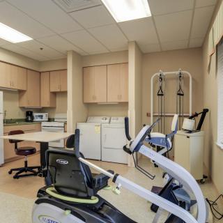A well-equipped rehabilitation room with stationary bikes and therapy equipment.