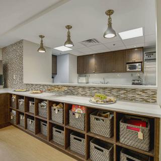 A modern kitchen space with organized storage baskets and stylish lighting.