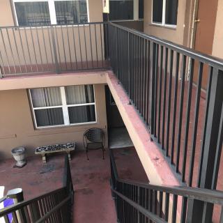 A view of an apartment courtyard with a staircase and balconies.
