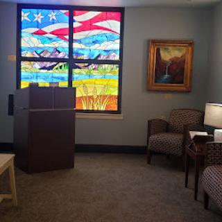 A cozy interior space featuring a vibrant stained glass window and comfortable seating.